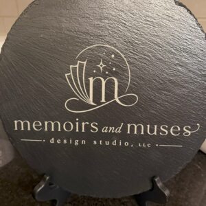 12 inch round natural slate sign laser-engraved with a business logo, shown on a display stand